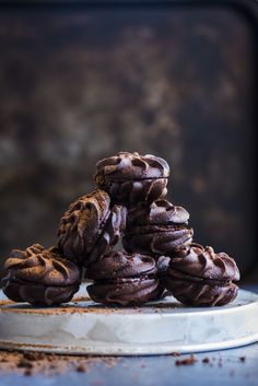 a pile of chocolate cookies sitting on top of a metal pan covered in frosting