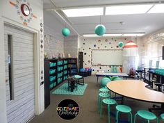 a classroom with tables, chairs and lots of books on the shelves in front of them