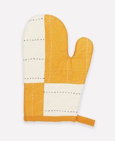 an oven mitt made out of yellow and white fabric with stitching on it