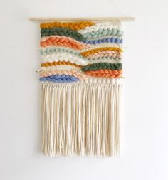 a wall hanging made out of multicolored yarn