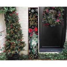 two christmas wreaths are next to a black door with holiday decorations on the front