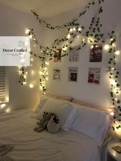 a bed with white sheets and lights on the wall above it is decorated with ivy