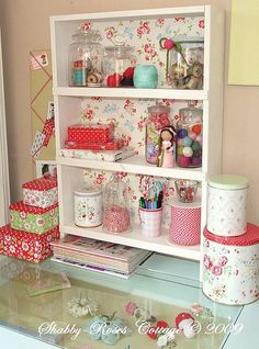 there is a shelf that has many items on top of it, including wrapping paper and other crafting supplies