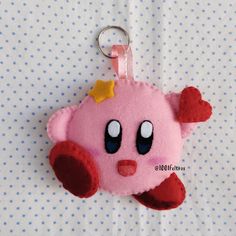 a pink stuffed animal keychain with a star on it's head and eyes