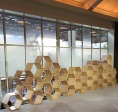 a room with several wooden hexagonal shelves on the wall