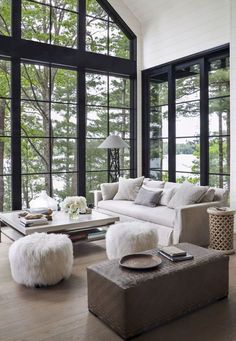 a living room filled with furniture and lots of large windows in the wall next to each other