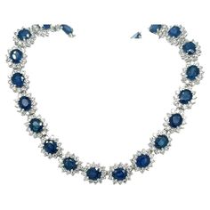 Introducing a circle link 18k white gold choker necklace with natural Blue Sapphires and diamonds. 40 individual links each containing a vivid no heat Blue Sapphire. The Sapphires are oval cut, totaling approximately 36.0 carats total and measuring 6x5 mm. 4-prong set Blue Sapphire with 12 round cut diamonds forming a halo in a shared prong mounting. 480 diamonds totaling approximately 9.60 carats total. Diamonds are H-I color, SI1-SI2 Clarity. Necklace set in 18k white gold, measuring 17 inches