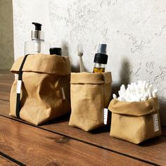 three bags are lined up on the table with soap and toothbrushes in them