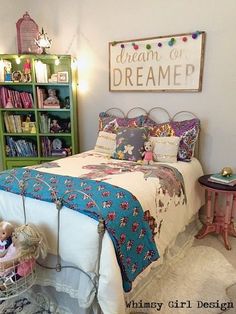 a bedroom decorated in pink, blue and green with lots of books on the shelves