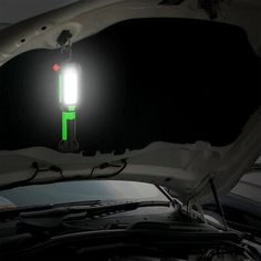 a car with its hood open and the light on is glowing green in the dark