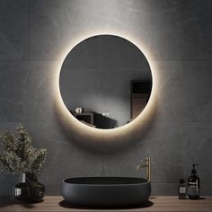 a bathroom sink with a round mirror above it and a vase on the counter next to it