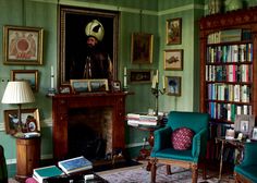 a living room filled with furniture and bookshelves next to a painting on the wall