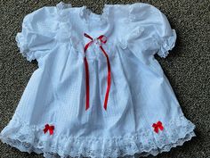 A just right white dress with lots of frilly lace and adorned with red ribbons perfect for showing off your little girl ages 12-24M New from Deadstock Antique Baby Dress, Yellow Baby Dress, White Baby Dress, Summertime Dresses, Smocked Baby Dresses, Baby Girls Dresses, White Flares, Phi Mu, Baby Jumpsuit