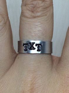 A perfect gift for any TXT fan, this hand stamped metal aluminum ring showcases the band name. I hand stamp each one of a kind aluminum ring, so spacing might be slightly different. This aluminum ring can be made in the size of your choice, but is pliable enough that it can be carefully tweaked if needed. To ensure the design stays dark, please avoid getting it wet and take it off before showering or swimming. Please let me know if you have any questions or custom requests. I'd love to create so Txt Jewelry, Hand Stamped Metal, Stamped Metal, Tomorrow X Together, Metal Stamping, Hand Stamped, Rings For Men, Let Me, Swimming