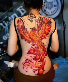 the back of a woman's body with a tattoo design on her lower back