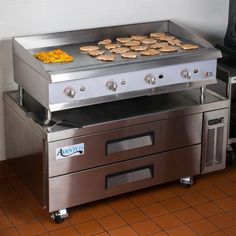 an industrial style grill with food cooking on it