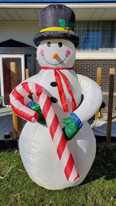 a large inflatable snowman holding a candy cane