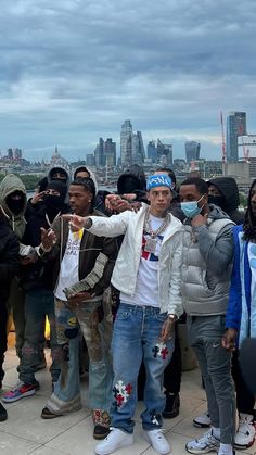 a group of young men standing next to each other in front of a city skyline