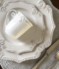 a white plate topped with a cup and saucer