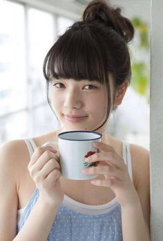 a woman is holding a coffee cup and smiling