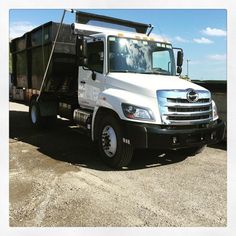 a large white truck parked on top of a dirt field