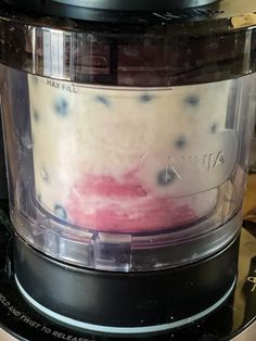 a food processor with blueberries and milk in it