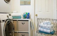 a washer and dryer in a small room next to a door with towels on it