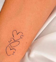 a woman's arm with a tattoo that has hearts and arrows drawn on it