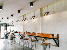 the interior of a modern restaurant with wooden bar stools and white walls stock photo