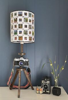 a lamp that is sitting on top of a table next to a camera and other items