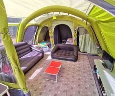 an inside view of a tent with couches and other items on the ground in front of it