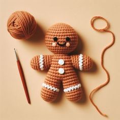 a crocheted ginger is next to a ball of yarn and a knitting needle