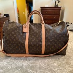 Beautiful, Authentic Lv Keepall Bandouliere 60, This Is The Big One! Bag Was Only Used Twice And Is Very Clean. There Are A Few Small Rubs, You Have To Look Close, A Couple Of Marks On The Vachetta And Handles. There Is A Black Scuff On The Bottom Of The Bag, You Can See It On The Left Side In The Last Picture, It Is In The Dark Brown And Does Not Cross Into The Monogram Pattern. The Interior Is Very Clean And Odor Free. Flaws Shown In Pics So Zoom In Closely And Ask Any Questions. Comes With Strap And Luggage Tag Only. I Have The Dustbag Which Is Negotiable. Luxury Travel Bag In Signature Coated Canvas, Luxury Signature Coated Canvas Travel Bag, Luxury Brown Travel Bag With Gold-tone Hardware, Luxury Beige Bags In Signature Coated Canvas, Luxury Beige Signature Coated Canvas Bag, Designer Travel Bag In Signature Coated Canvas, Designer Signature Coated Canvas Travel Bags, Designer Brown Travel Bag With Gold-tone Hardware, Elegant Monogram Canvas Travel Bag