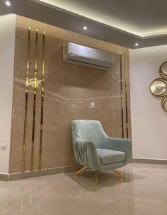 a blue chair sitting next to a wall mounted air conditioner in a living room