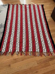 two rugs on the floor next to each other with red, white and black stripes