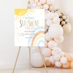 there is a sign and balloons in front of the wall that says sunshine shine on it