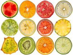 various fruits cut in half on a white background, including kiwis and oranges