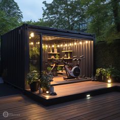 an outdoor gym is lit up at night with lights on the floor and potted plants