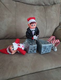 two elfs are sitting on a couch with presents in their hands and one is laying down