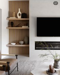 a living room with a large flat screen tv mounted on the wall next to a fireplace