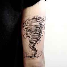 a black and white photo of a person's arm with a tattoo on it