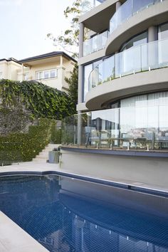 an empty swimming pool in front of a large building with balconies on it