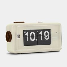 an alarm clock with the time 10 19 on it's face and two brown buttons