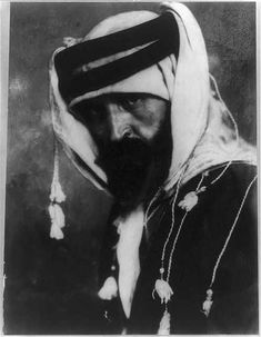 an old black and white photo of a man with a beard wearing a turban