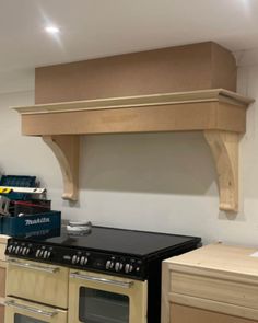 a stove top oven sitting inside of a kitchen next to a wall mounted range hood