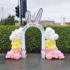 two bunny ears are on top of balloons in front of a gate