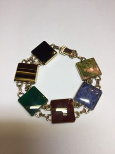 "This bracelet from the 1950's. An alternative to the scarab bracelet. The bracelet is marked WRE 1/20 12kgf on the fold over catch. There is some wear on the back of the catch. It has all genuine stones, onyx, green and black, carnelian, tiger eye, agate and sodalite. Each stone measures 5/8\". There is some minor surface scratching on the stones from everyday wear. It measures 7 1/2\" long. Any questions, please email me." Scarab Bracelet, Hand Ring, Moonstone Ring, Fashion Books, Tiger Eye, Chain Link Bracelet, Link Bracelets, Vintage Gold, Arm Band