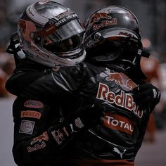 two men in racing gear hugging each other