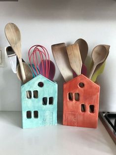 three wooden utensils and spoons are lined up on a kitchen counter top