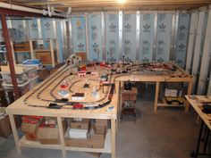 a room filled with lots of toy trains and wooden boxes on top of it's sides